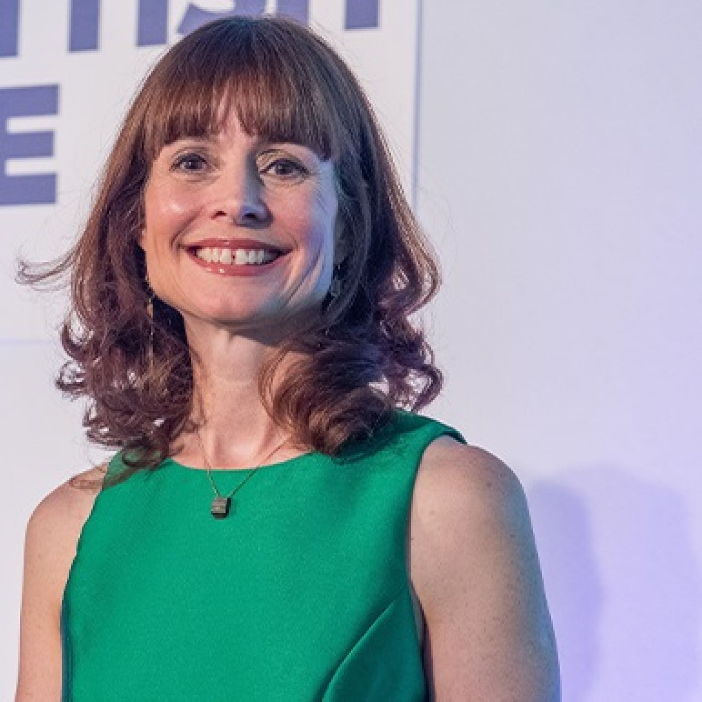 A square photo of Evelyn McDonald, GCU alumna, graduate and CEO of Scottish EDGE, smiling in a green dress.