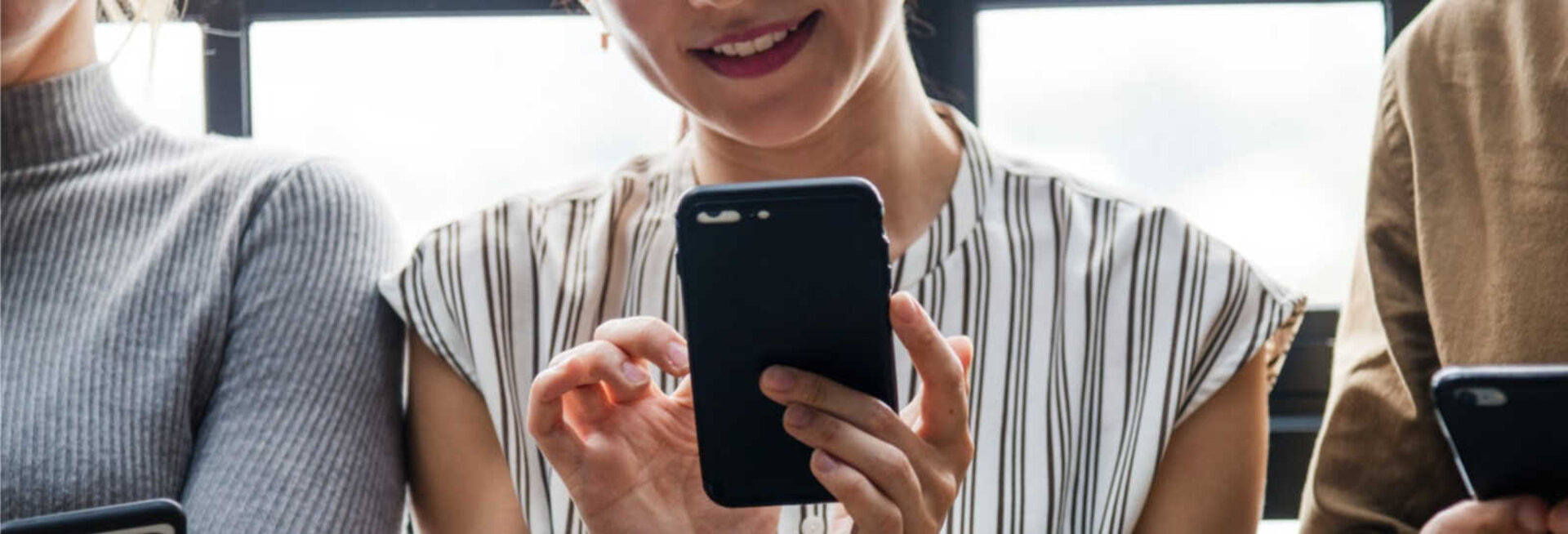 Three people side-by-side using their mobile phones.s