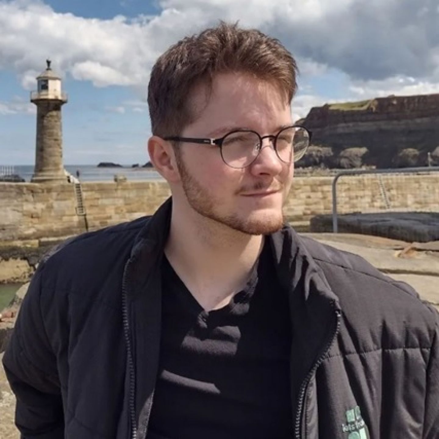 A profile image of GCU student and Common Good Scholarship recipient Darren Barrie, on a beach with a lighthouse in the background.
