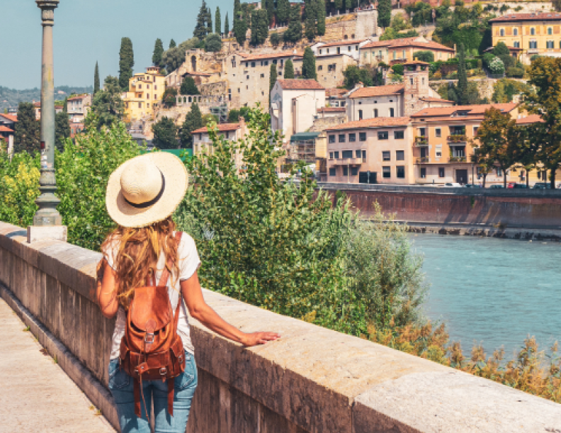 A photograph showing the back of a female looking out over a beautiful view.
