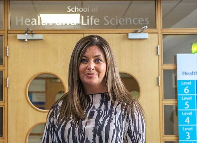 A photo of Deborah Clark, GCU alumna and Radiography graduate, in front of the School of Health and Life Sciences on Glasgow campus.
