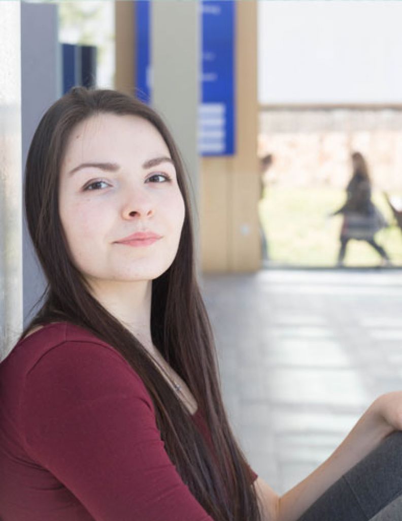 PG student sitting in a campus corridor 