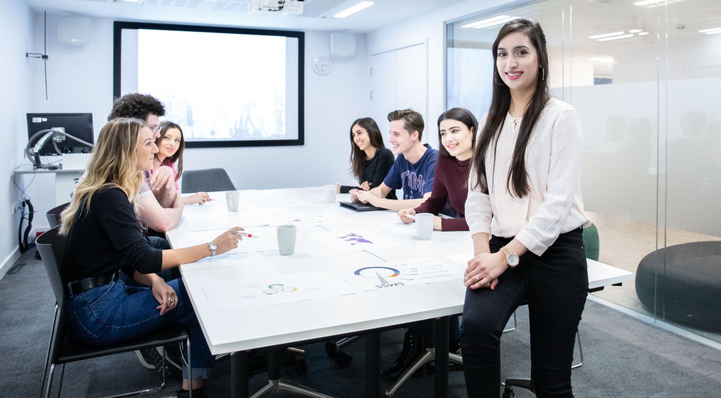 Students studying BA (Hons) International Business, working together in a study room on Glasgow campus.