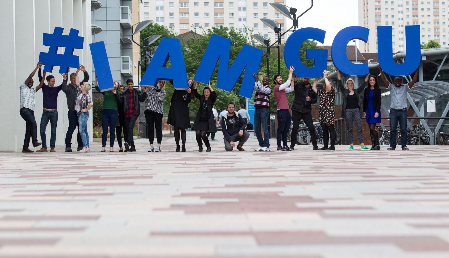 Students on campus with #I AM GCU sign