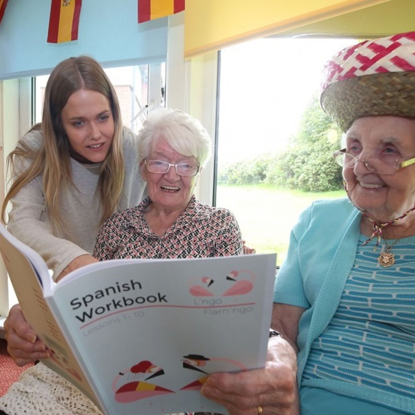 An image of a teacher giving language class in a care home for two residents.