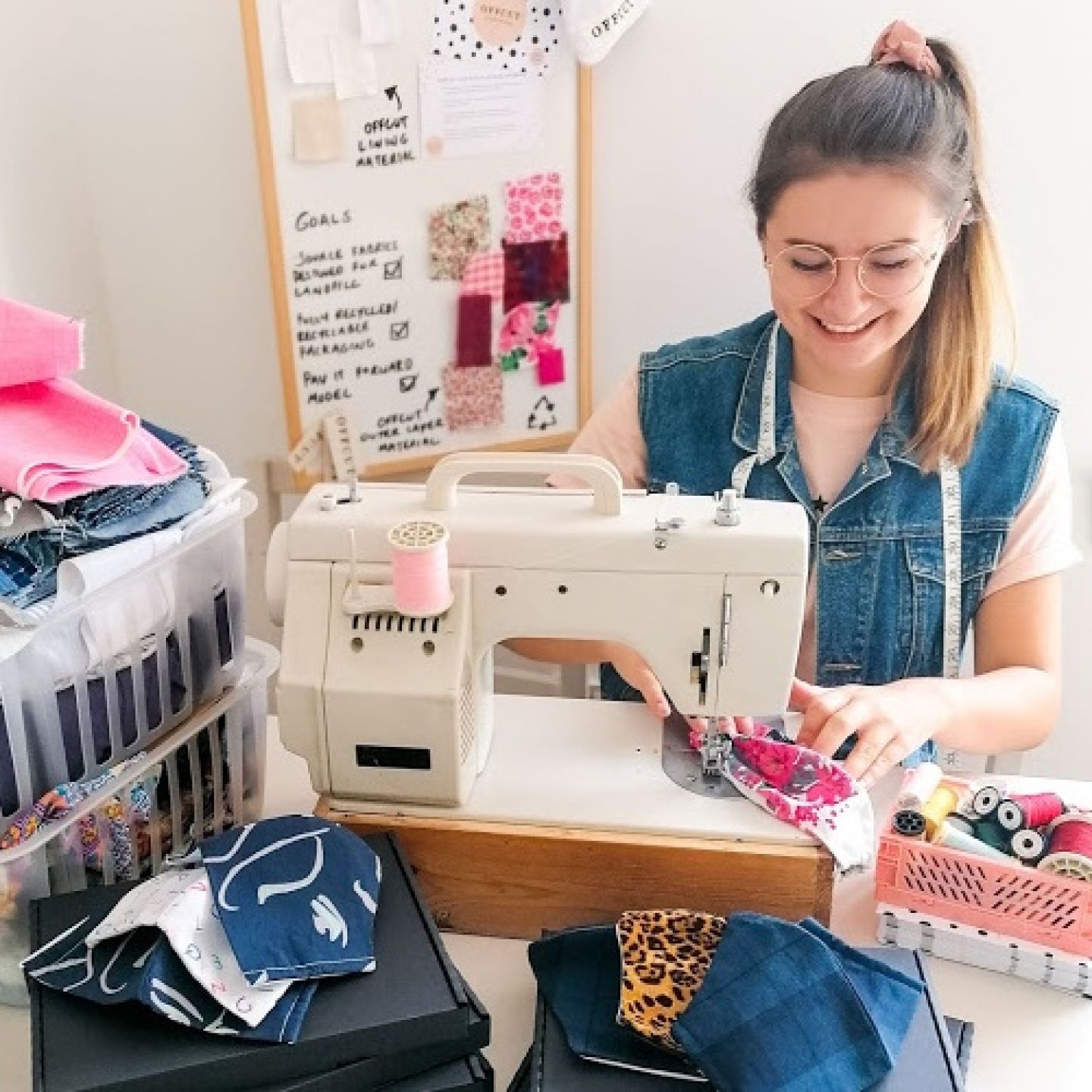 An image of GCU Graduate Georgia Barr smiling while using a sewing machine.