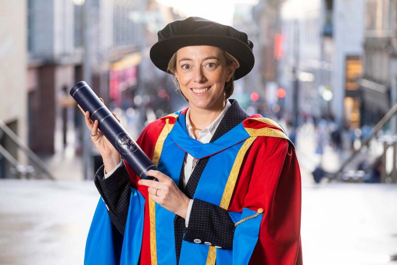 	GCU Honorary Graduate Dr Nicole Taylor wearing her graduation hood and hat and holding a degree container.