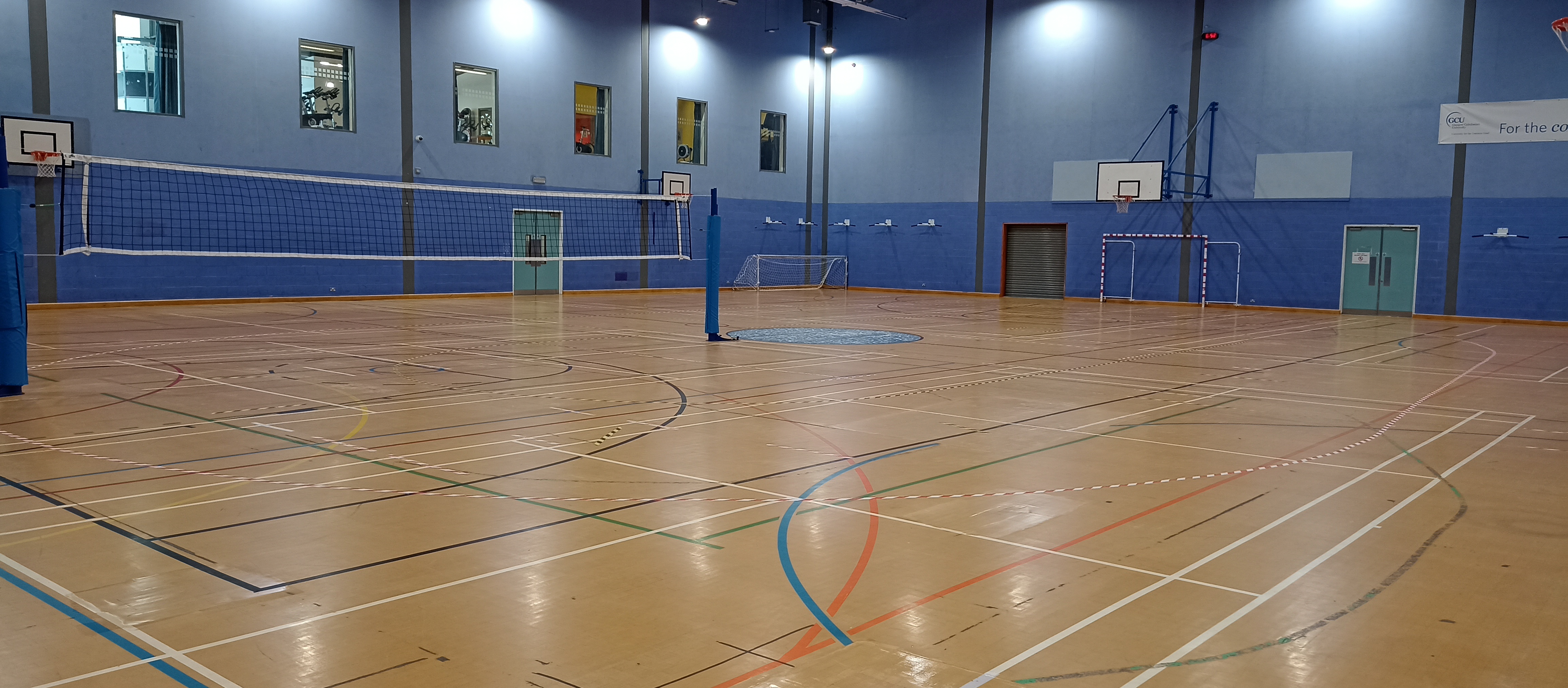 The large hall in the ARC building with volleyball set up in one half of the hall.
