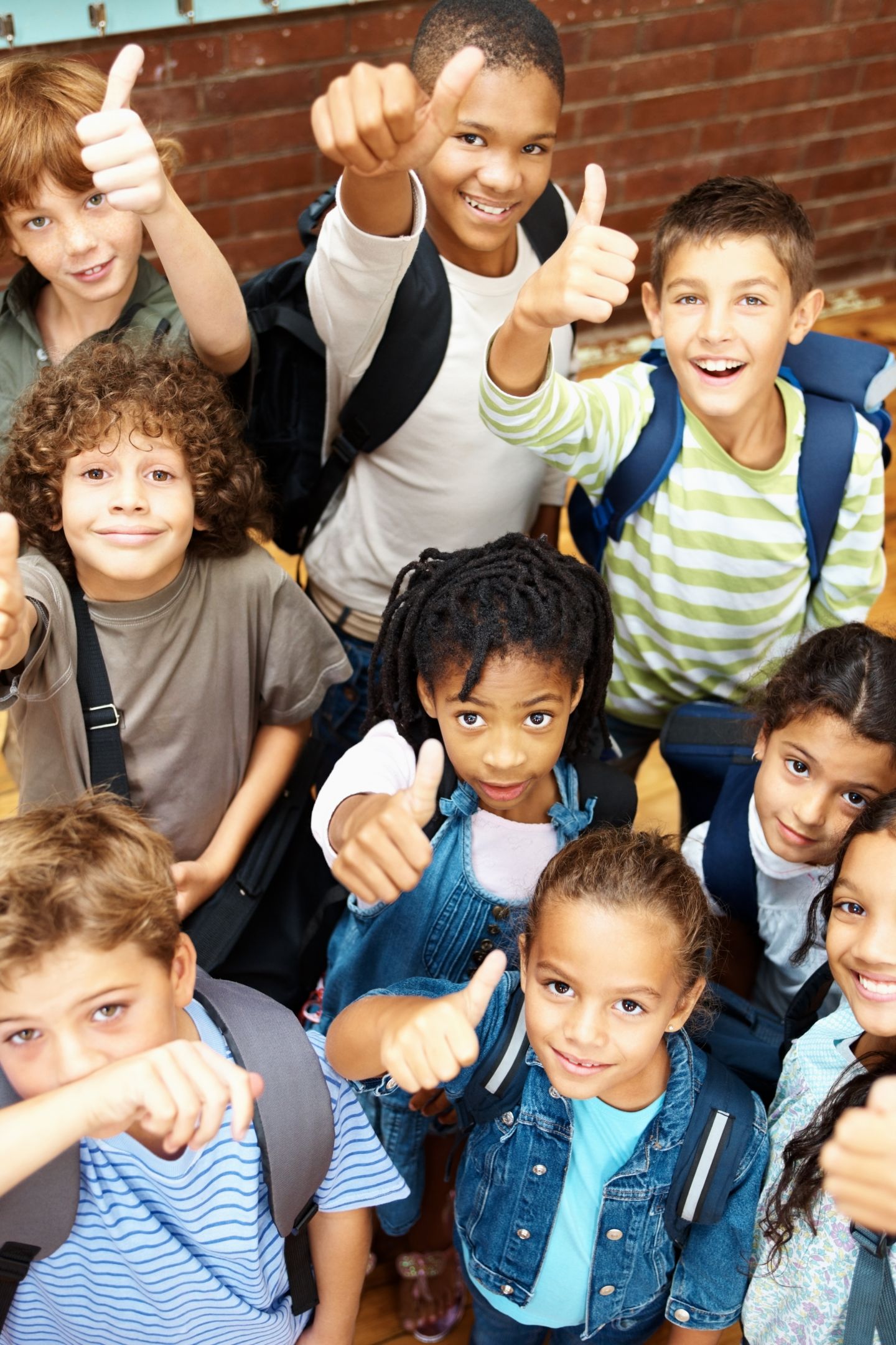 A group of children all giving a thumbs up and smiling