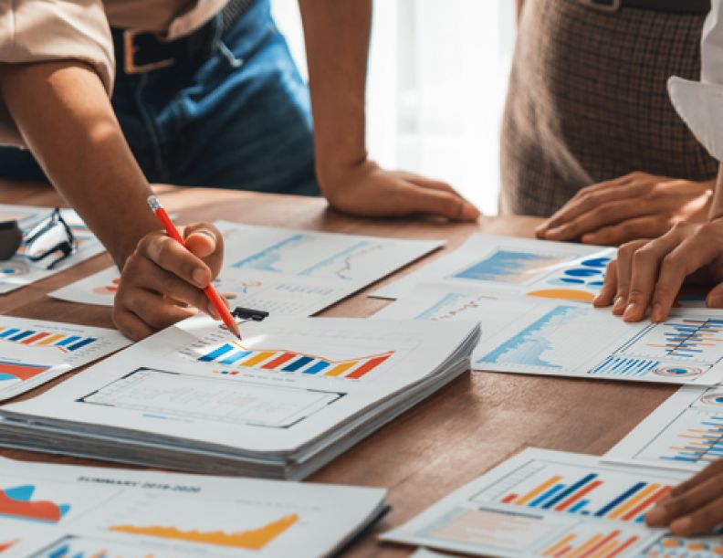 Group of Business Students with spread sheets and diagrams