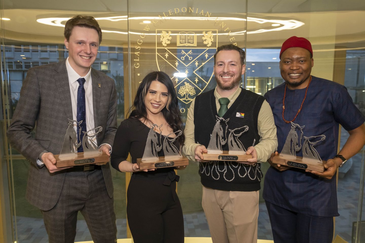 Group photo of the 4 GCU Alumni of the Year winners (AOTY) holding their AOTY awards.