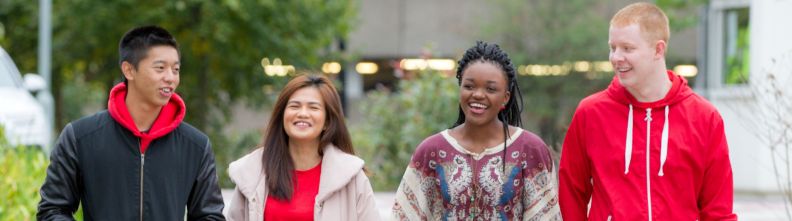 Four students walk towards the camera.