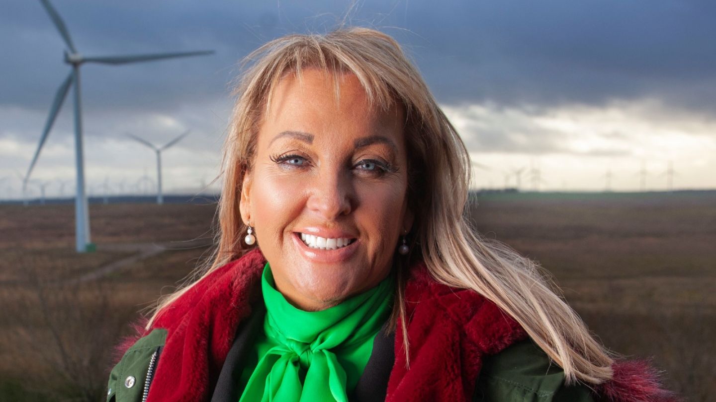 A photo of Dr Marie Macklin CBE smiling at a windmill farm